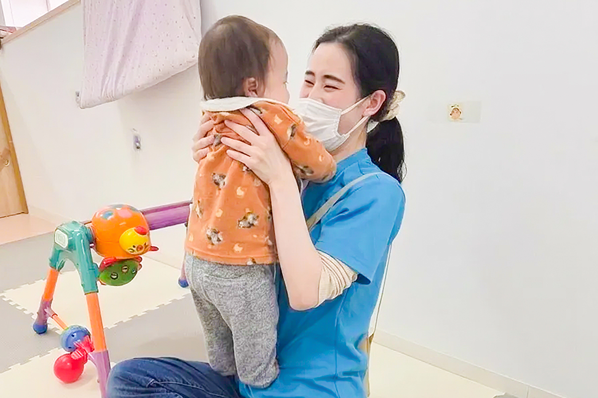 先生が子どもと遊んでいる写真。