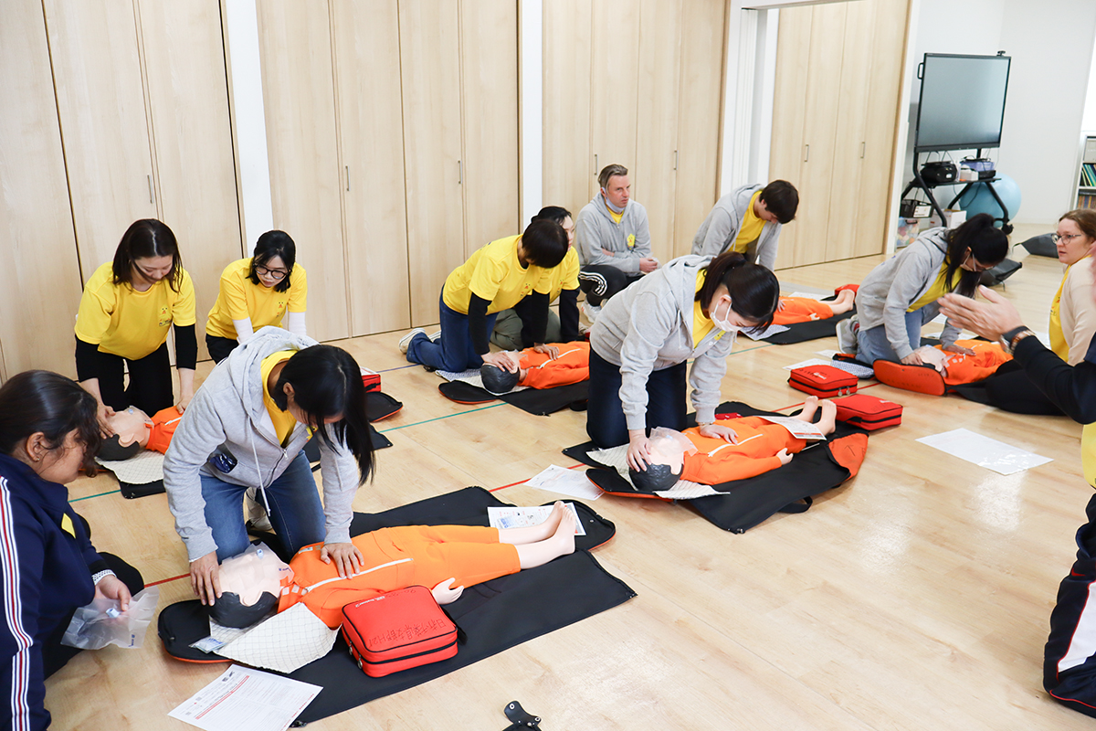 AEDの使用方法を学んでいる先生たちの写真